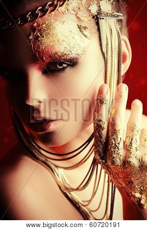Art project: beautiful woman with golden make-up. Jewelry, make-up. Fashion.