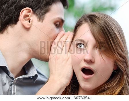 Man Whispering In The Ear Of His Surprised Wife