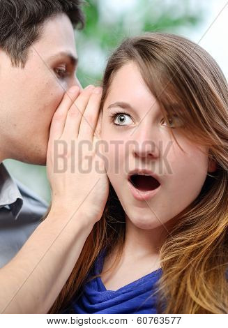 Man Whispering In The Ear Of His Surprised Wife