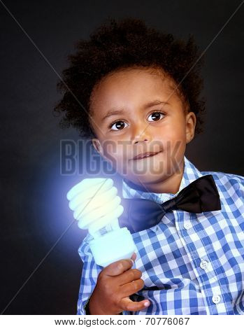 Portrait of a cute little schoolboy holding in hands bright lamp, smart boy learning science 