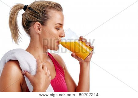 Woman getting ready for gym workout with towel and orange juice in studio