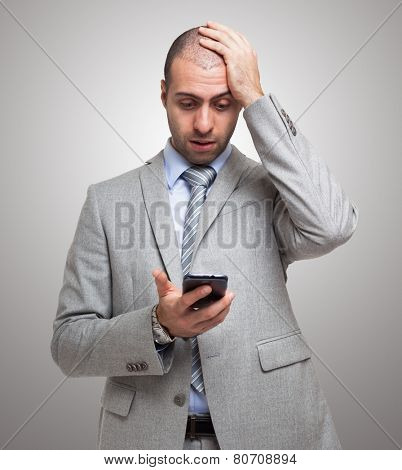 Portrait of a surprised man looking at his smartphone