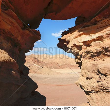 Venster in de oranje zandsteen rotsen in de Negev-woestijn Israël
