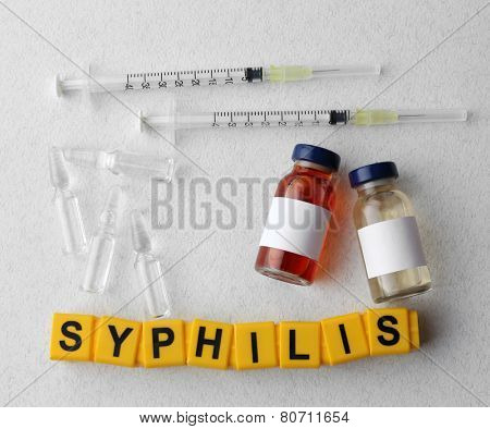 Syphilis word and medical equipment on light background
