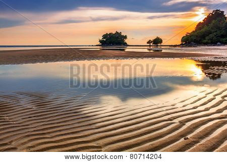 Tropical beach in ebb time on sunset background