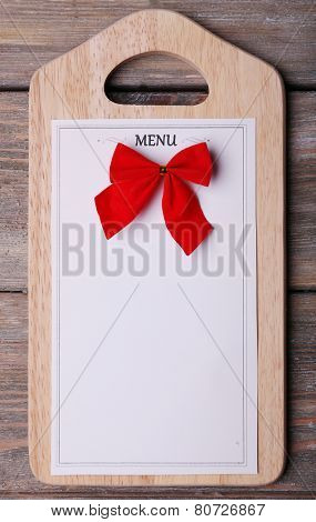Cutting board with Menu sheet of paper on rustic wooden surface background
