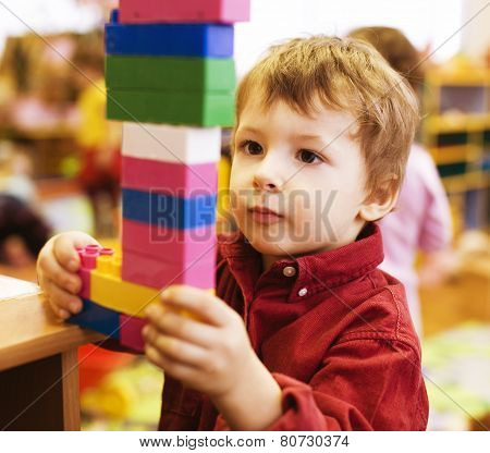 portrait of little cute  real boy making towel with lego