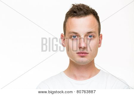 Portrait of a handsome young man, perfectly calm, facing the camera with emotionless expression