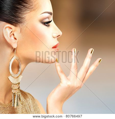 Profile portrait of the beautiful fashion woman with black makeup and golden manicure