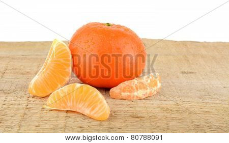 Mandarine With Pieces Isolated On Wooden Table