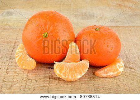 Mandarines With Pieces Isolated On Wooden Table