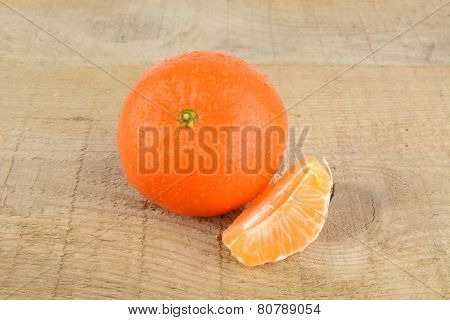 Mandarine With Pieces Isolated On Wooden Table
