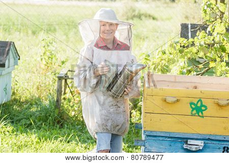 Teenage beekeeper checking hives on bee yard