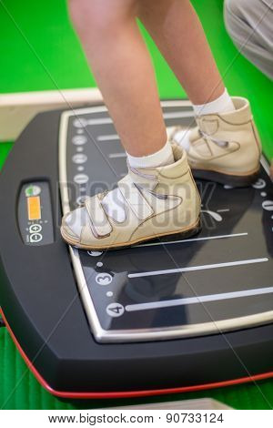 child feet on a vibrating training platform