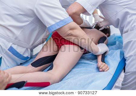 a group of doctors injections boy back on medical table