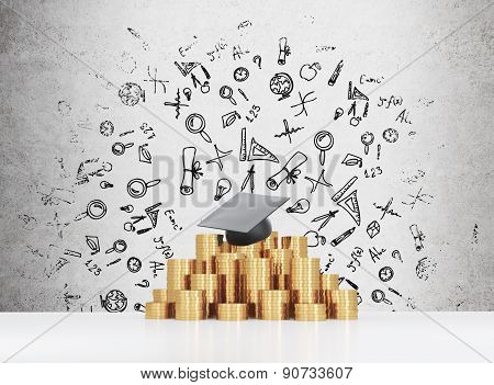 Graduation Hat Is Laying On The Coins Pyramid. A Concept Of A High Price For The University Educatio