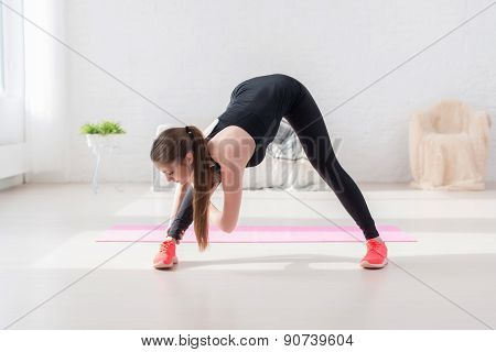 Athletic woman doing stretching exercise her hamstrings and back forward bend lean down aerobics or