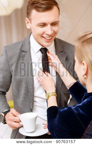 Woman fixing tie of handsome man