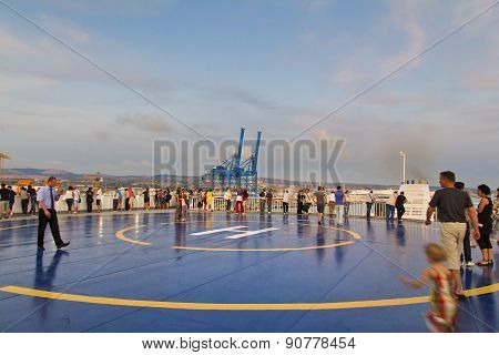 Tourists In Helipad For Helicopter On The Upper Deck Of Big Cruise Ship