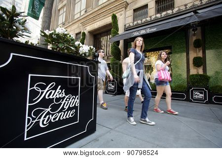 NEW YORK CITY - FRIDAY, MAY 8, 2015: Pedestrians walk past Saks Fifth Avenue in Manhattan. Saks Fifth Avenue is an American department store chain owned by the Hudson's Bay Company.