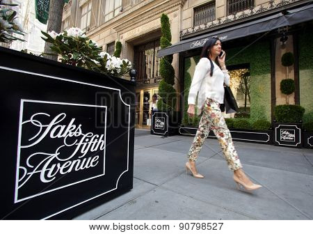 NEW YORK CITY - FRIDAY, MAY 8, 2015: Pedestrians walk past Saks Fifth Avenue in Manhattan. Saks Fifth Avenue is an American department store chain owned by the Hudson's Bay Company.