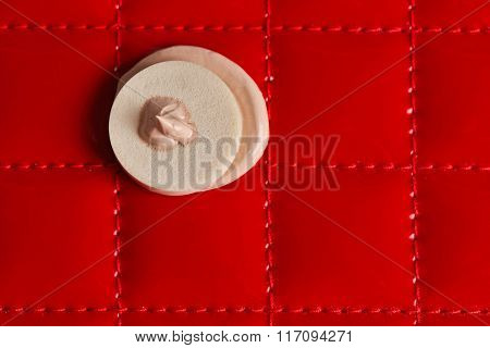 Makeup sponge with liquid foundation on abstract background