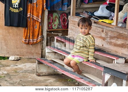 One Child On Bench At The Shop In The Village Of Tana Toraja