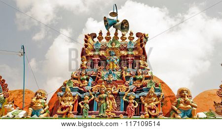 Decorated temple entrance gopuram or tower captured against cloudy sky background