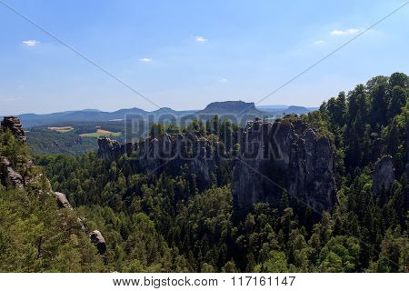 Panorama With Rocks Bastei, Neurathen Castle And Table Mountain Lilienstein In Rathen, Saxon Switzer