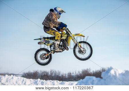 closeup rider on a motorcycle jump on mountain. background blue sky