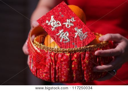 People Held The Orange Basket With Blessing Red Envelope For Chinese New Year Gifts, The Word Is May