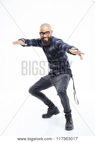 Happy african american young bearded man in glasses balancing and dancing 