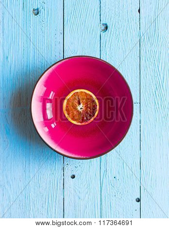 Colorful Orange fruits over a light blue painted wood table with a simmetric position.
