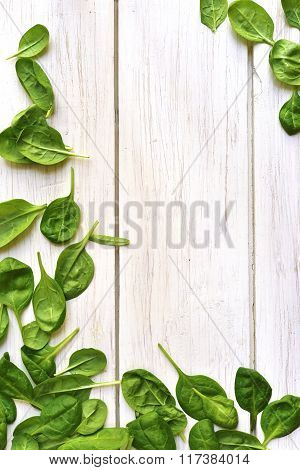 Baby Spinach Leaves On A White Wooden Table.