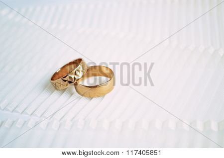 Two Golden Wedding Rings On Light Ribbon Background