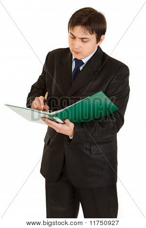 폴더를 손에 들고와 화이트에 고립 된 문서에 메모를 만들고 심각한 젊은 사업가