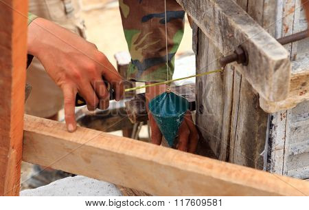 Labor Man Using A Plumb Bob For Check .