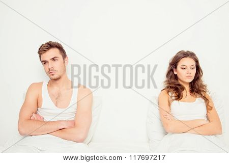 Young Disconnected Couple Sitting On The Bed