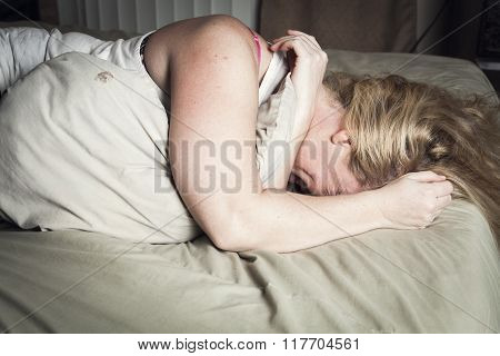 A woman feel sick lying down on bed