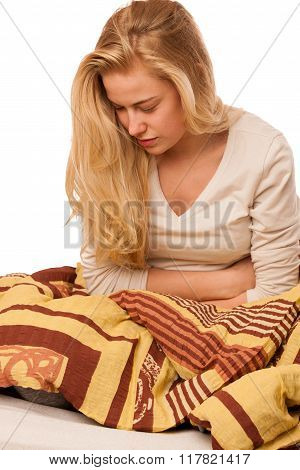 Woman Sitting On Bed Holding Belly Because Of The Pain In Stomac.
