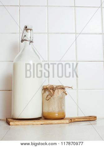 real comfort wooden kitchen with breakfast ingredients close up in glass, honey, oatmeal, milk, mues