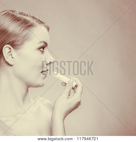 Young Woman Take Balm On Lips.