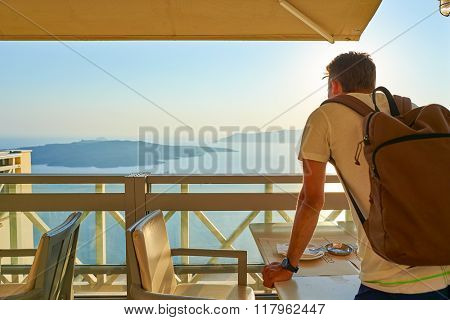 SANTORINI, GREECE - AUGUST 07, 2015: man posing in the cafe on Santorini island. Santorini, classically Thera, and officially Thira, is an island in the southern Aegean Sea