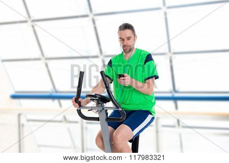 Young Man Train With Fitness Machine And Listening Music