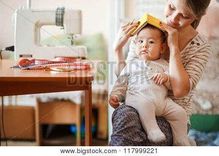 Raising children, child care, baby sitter. Mother and infant at home playing role-playing games. Cut