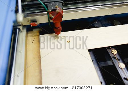 The automatic machine burns the window on the workpiece with a laser close-up. There is smoke from work