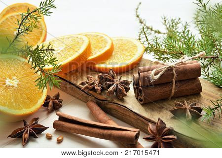 fresh oranges with anisestars, cinnamon sticks, juniper branches and aroma candle, Christmas time composition