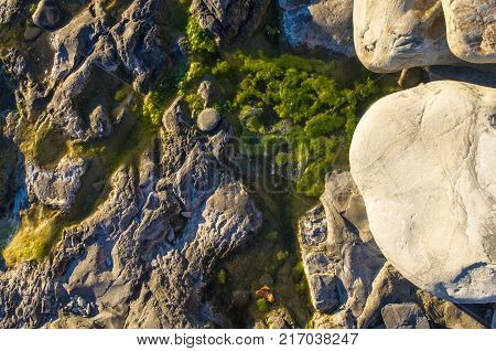 boulders and colorful pebbles on the beach on a warm summer day