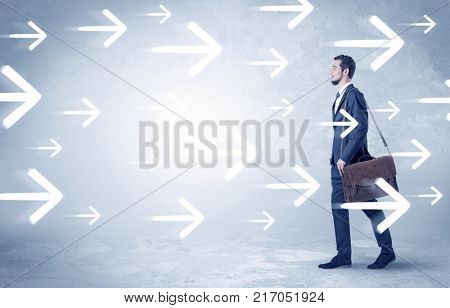 Businessman walking with arrows on the background and briefcase on his hand
