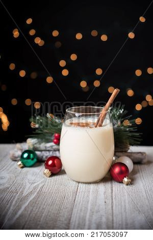 Egg nog in a glass with Christmas oranments